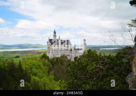 Bayerisches Schloss Neuschwanstein in den Alpen und Forggensee im Hintergrund fotografiert von der Marienbrücke (Bayern, Deutschland) Stockfoto