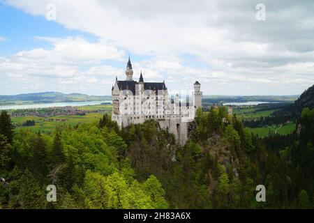 Bayerisches Schloss Neuschwanstein in den Alpen und Forggensee im Hintergrund fotografiert von der Marienbrücke (Bayern, Deutschland) Stockfoto