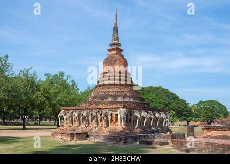 Eine alte buddhistische Stupa mit Elefantenskulpturen auf den Ruinen des Wat Sarosak Tempels an einem sonnigen Tag. Sukhotai, Thailand Stockfoto