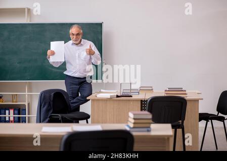 Alte Lehrerin vor der Tafel Stockfoto