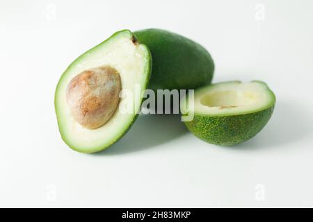 Avocado ganz und halb auf weißem Hintergrund. Natürliches Lebensmittelkonzept. Nahaufnahme Stockfoto