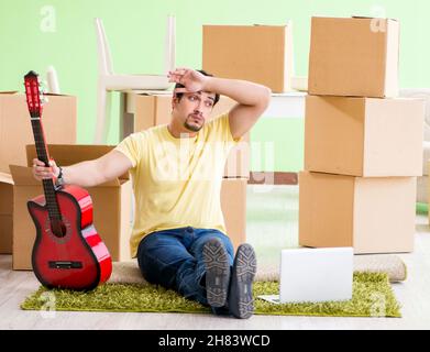 Der junge, gutaussehende Mann zieht mit in ein neues Haus Boxen Stockfoto