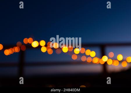 Außerhalb des Fokus weihnachtslichter auf dem Geländer eines Balkons in der Nacht Stockfoto