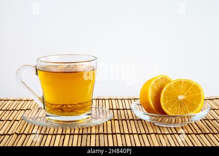 Grüner Tee Tasse und Zitrone auf Holzhintergrund Stockfoto