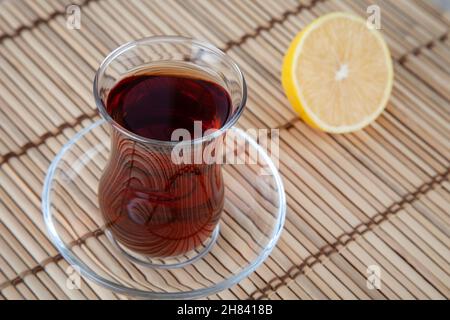 Glas Tasse Tee und Zitrone auf Korbweide, Draufsicht Stockfoto