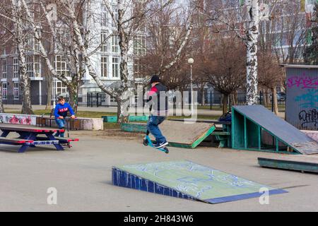 Krasnodar, Russland - 20. Februar 2020: Jugendliche fahren Roller, die verschiedene Tricks auf dem alten Sportplatz ausführen Stockfoto