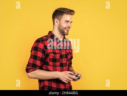 Leben in der digitalen Welt. Männliches Hobby und Freizeit. Gamer in karierten Hemd. Glücklich bärtigen Kerl verwenden Spielkonsole. Unrasiert schöner Mann mit Joystick Stockfoto