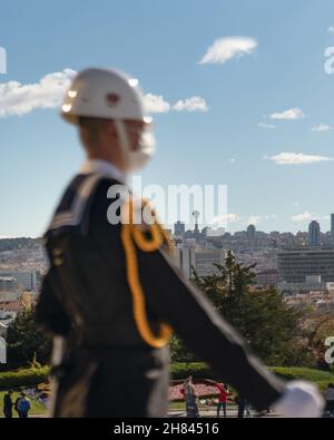 Unfokussierter, verschwommener Soldat mit medizinischer Gesichtsmaske steht Wache am Mausoleum und Panoramablick auf Ankara im Hintergrund. Stockfoto