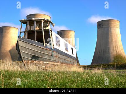 Altes, enges Boot auf einem Feld in der Nähe eines Kraftwerks Stockfoto