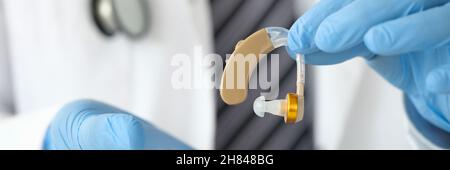 Arzt Otorhinolaryngologe, der Hörgeräte in der Nähe in den Händen hält Stockfoto