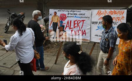 Mumbai, Indien. 27th. November 2021. Die Menschen gehen an einem Gemälde der Gurukul School of Art vorbei, um Bewusstsein für die neue Variante des Coronavirus zu schaffen, die in Südafrika entstanden ist.die Brihanmumbai Municipal Corporation (BMC) wird vorsorglich südafrikanische Rückkehrer bei ihrer Ankunft in Mumbai isolieren. Kredit: SOPA Images Limited/Alamy Live Nachrichten Stockfoto