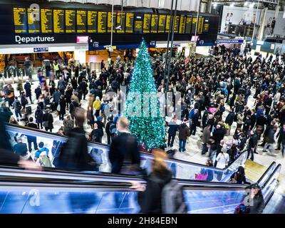 WEIHNACHTEN BAHNHOF CONCOURSE ABFAHRTEN STADT PENDLER VERLASSEN WEIHNACHTSBAUM LONDON WATERLOO erhöhte Ansicht der geschäftigen concourse und verschwommen Rolltreppe am Waterloo Station an Weihnachten London SE1 Stockfoto