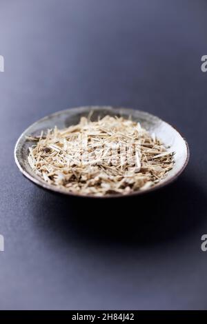 Trockener sibirischer Ginseng (Eleutherococcus senticosus) auf dunklem Papierhintergrund. Nahaufnahme. Stockfoto