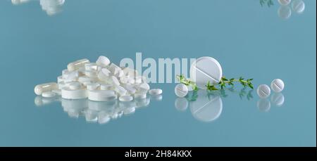 Tabletten mit einem Stab einer Heilpflanze. Berg Pillen und Rollen. Stockfoto