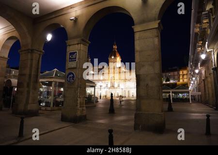 Schöner Blick auf ein Rathaus auf Praza de Maria Pita gegen einen dunklen Nachthimmel in Coruna, Spanien Stockfoto