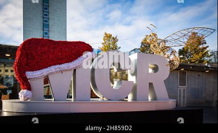 MCR mit Weihnachtsmütze und goldener Manchester Bee in Piccadilly Gardens, Manchester, England, Großbritannien. 2021 Stockfoto