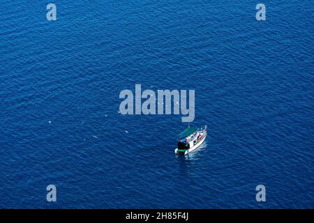 Kleines Ausflugsboot im Meer, Blick von oben Stockfoto