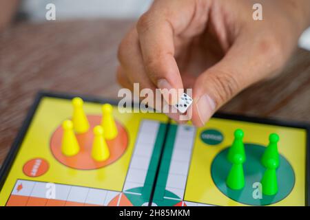 Nahaufnahme der Hand, die beim Spielen von Ludo Würfel hält Stockfoto