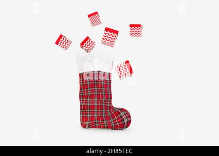 Geschenke fliegen aus Santa's Boot.Greeting Karte, Banner, Poster.Copy space.Christmas Home Dekor, Komposition.Gifts, rote Dekorationen.Santa's Weihnachtsstiefel Stockfoto