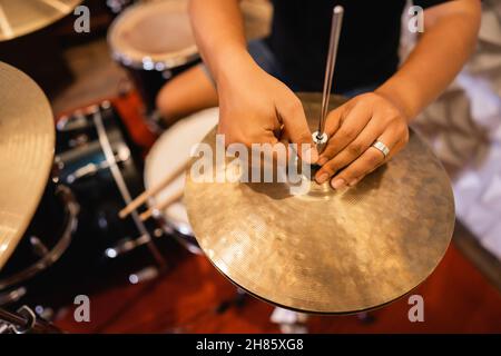 Nahaufnahme der Hand eines Schlagzeugers, der vor der Verwendung Hi-hat-Kupplungs-Becken aufsetzt Stockfoto