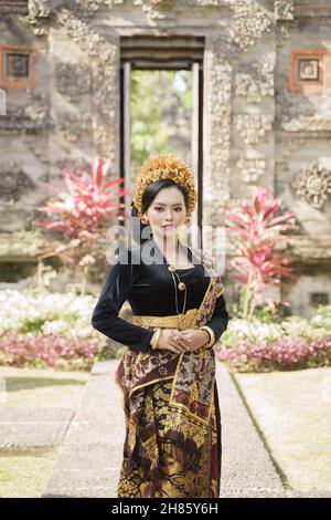 Schöne Frau in traditioneller balinesischer Kleidung stehend Stockfoto