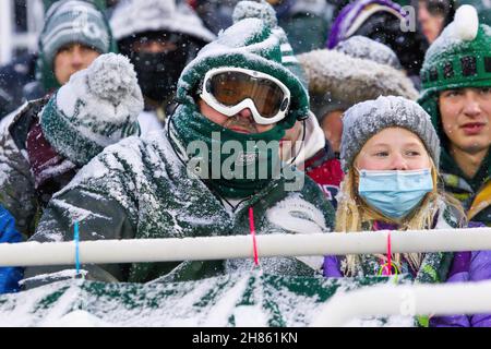 East Lansing, Michigan, USA. 27th. November 2021. Michigan State-Fans versuchen, sich beim Sieg des Staates Michigan 30-27 über Penn State im Spartan Stadium warm zu halten. (Bild: © Scott Mapes/ZUMA Press Wire) Stockfoto