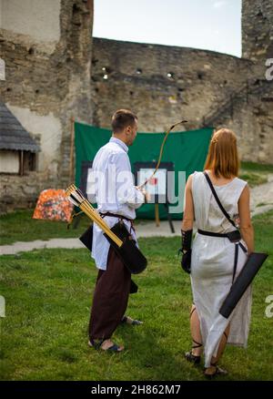 Menschen in mittelalterlichen Kleidern mit Bögen auf dem Gebiet der Burg Stockfoto