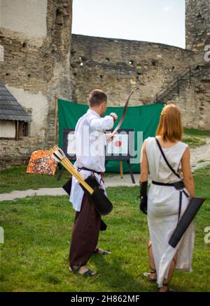 Menschen in mittelalterlichen Kleidern mit Bögen auf dem Gebiet der Burg Stockfoto