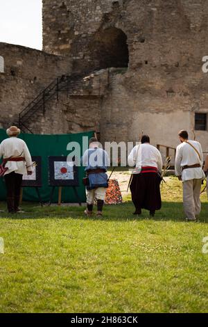 Menschen in mittelalterlichen Kleidern mit Bögen auf dem Gebiet der Burg Stockfoto