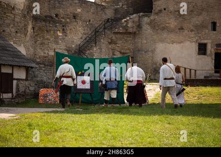 Menschen in mittelalterlichen Kleidern mit Bögen auf dem Gebiet der Burg Stockfoto