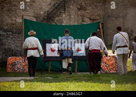 Menschen in mittelalterlichen Kleidern mit Bögen auf dem Gebiet der Burg Stockfoto