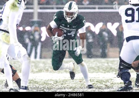 East Lansing, Michigan, USA. 27th. November 2021. Der Michigan State, der sich gegen ELIJAH COLLINS (24) zurückläuft, trägt den Ball während des 30-27-Sieges des Michigan State gegen Penn State im Spartan Stadium. (Bild: © Scott Mapes/ZUMA Press Wire) Stockfoto