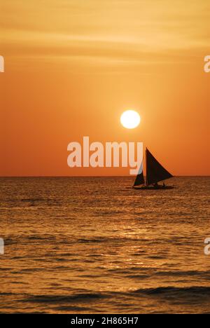 Der Sonnenuntergang in Boracay bietet einen atemberaubenden Sonnenuntergang am Strand von Boracay. Eine entspannende Art, nach einem Tag in der tropischen Atmosphäre der Insel zu entspannen. Stockfoto