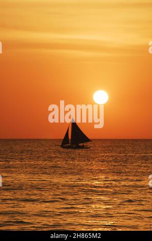 Der Sonnenuntergang in Boracay bietet einen atemberaubenden Sonnenuntergang am Strand von Boracay. Eine entspannende Art, nach einem Tag in der tropischen Atmosphäre der Insel zu entspannen. Stockfoto