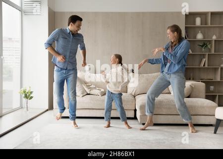 Glückliche junge Paar Eltern tanzen mit kleinen Tochter. Stockfoto