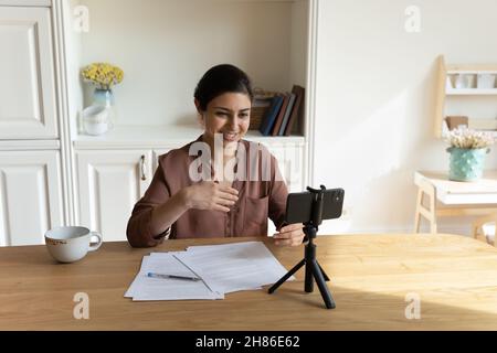 Lächelnd schöne junge indische Frau, die Bildungsvideo aufnimmt. Stockfoto