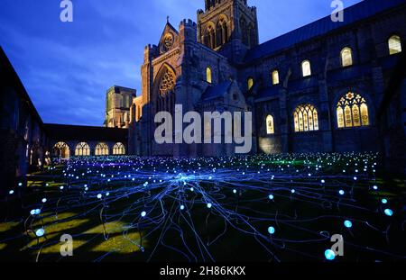 Im Kreuzgang der Chichester Cathedral werden 1.000 Leuchtenstämme mit wechselnden Farben als Teil einer immersiven Kunstinstallation des britischen Künstlers Bruce Munro mit dem Titel „Field of Blooms“ ausgestellt. Bilddatum: Samstag, 27. November 2021. Stockfoto