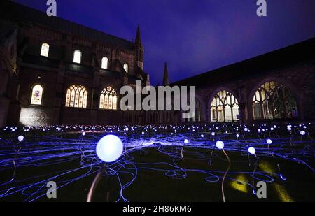 Im Kreuzgang der Chichester Cathedral werden 1.000 Leuchtenstämme mit wechselnden Farben als Teil einer immersiven Kunstinstallation des britischen Künstlers Bruce Munro mit dem Titel „Field of Blooms“ ausgestellt. Bilddatum: Samstag, 27. November 2021. Stockfoto