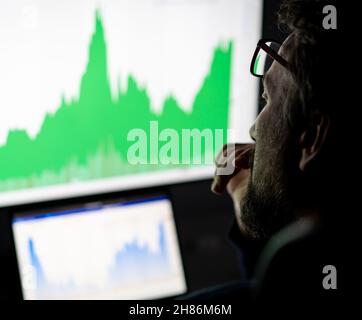 Analysten von Krypto-Händlern, die auf dem Computerbildschirm an den Online-Aktienmarkt denken, der mit globalen Risiken für Investitionen umgeht. Stockfoto