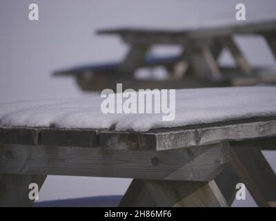 Schneebedeckter Holzparktisch Stockfoto