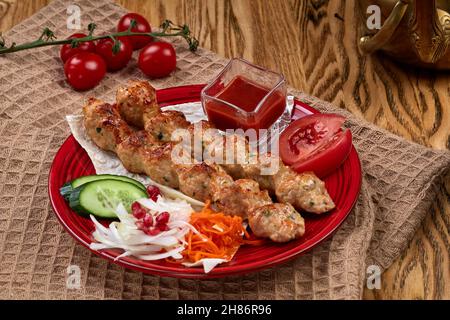 Gegrillter lula Kebab mit Salat auf Holztisch Stockfoto