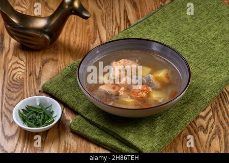 Eine Schüssel Fischsuppe auf einer Serviette auf einem Holztisch Stockfoto