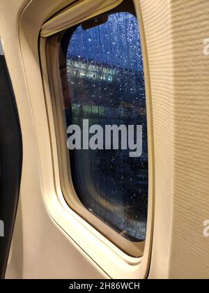 Flugzeugfenster in der Nähe. Regnerisches Wetter vor dem Start Stockfoto