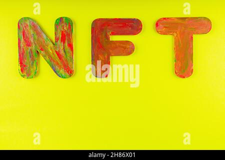 Nicht fungibler Token. NFT Akronym für mehrfarbige Buchstaben auf gelbem Hintergrund. Crypto Art Konzept. Speicherplatz kopieren. Draufsicht Stockfoto