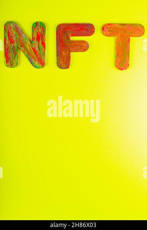 Nicht fungibler Token. NFT Akronym für mehrfarbige Buchstaben auf gelbem Hintergrund. Crypto Art Konzept. Speicherplatz kopieren. Draufsicht Stockfoto