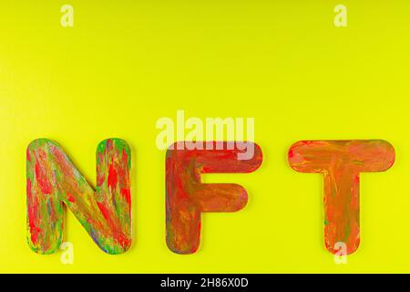 Nicht fungibler Token. NFT Akronym für mehrfarbige Buchstaben auf gelbem Hintergrund. Crypto Art Konzept. Speicherplatz kopieren. Draufsicht Stockfoto