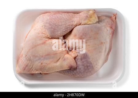 Zwei ganze Hühnerbeine in Kunststoff-Food-Tablett zum Verkauf auf dem Markt isoliert auf weiß in der Draufsicht Stockfoto
