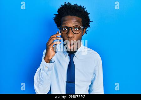 Junger afroamerikanischer Mann mit Gespräch auf dem Smartphone Angst und erstaunt mit offenem Mund für Überraschung, Unglauben Gesicht Stockfoto