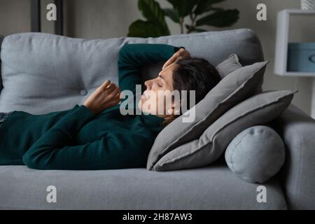 Ängstliche tausendjährige Frau, die auf dem Rücken liegt und nicht einschlafen kann Stockfoto