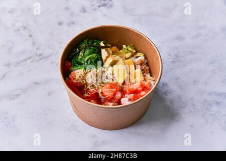 Köstliche Take-Away-Poke-Schüssel auf einer Marmoroberfläche Stockfoto